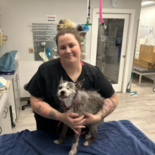 A veterinary employee hugging a one-eyed dog